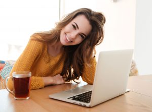 smiling-young-woman-working-on-laptop-at-home